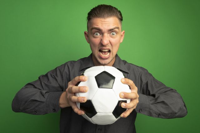 images/young-handsome-man-grey-shirt-holding-soccer-ball-shouting-with-aggressive-expression.jpg